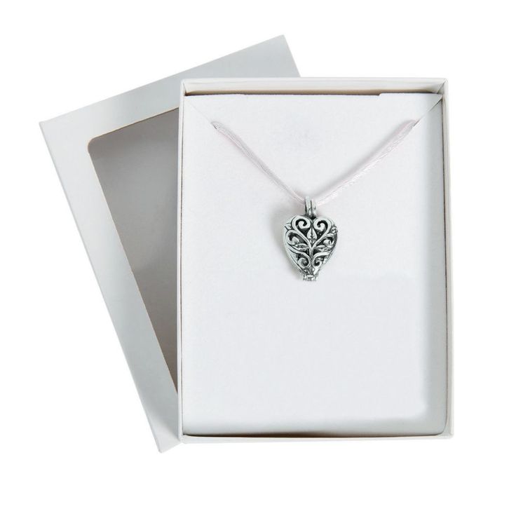 an open white box with a silver pendant in it's front and back corner