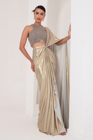 Grey and gold toned pre-draped saree crafted in metallic georgette. Paired with a sleeveless halter neck blouse with tonal crystal tassel and cutdana embellishments. - Aza Fashions Gold Pre-draped Saree For Reception And Festive Occasions, Fitted Gold Pre-draped Saree For Festive Occasions, Gold Pre-draped Saree For Diwali Reception, Glamorous Draped Choli With Zari Work, Glamorous Gold Saree For Designer Wear, Gold Saree With Pallu For Evening, Gold Pre-draped Saree For Diwali Evening, Elegant Gold Pre-draped Saree For Reception, Glamorous Draped Choli For Reception