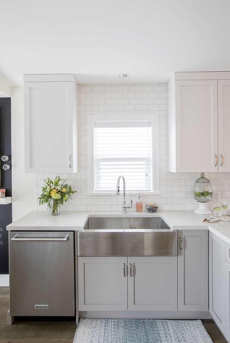 a kitchen with white cabinets and stainless steel sink, dishwasher in the middle