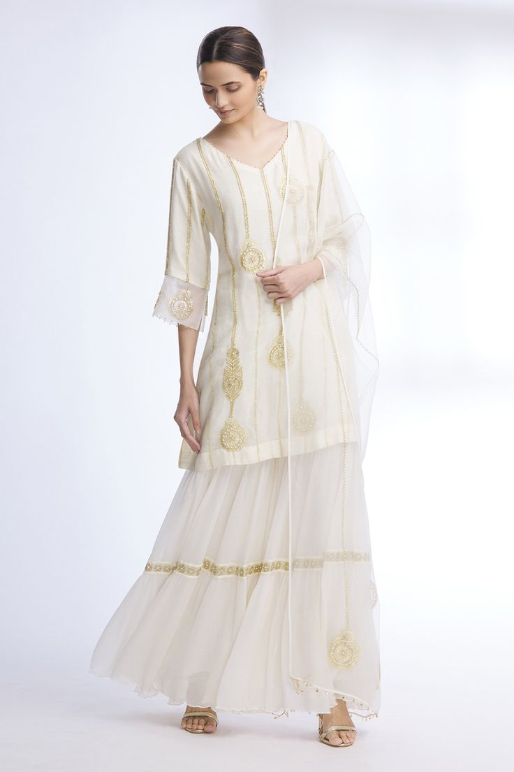 Off white kurta with floral embroidered motifs and stripes detail. Paired with sharara and sheer dupatta.
Components: 3
Fabric: Pure Silk Chanderi, Chiffon, Organza
Neckline: V neck
Sleeve Length: Three quarter
Color: White
Embroidered
Floral motif work
Sheer dupatta
Tiered sharara
Bead and pearl work
Flared sleeves - Aza Fashions Sheer Dupatta, Pearl Work, Kurta Set For Women, Embroidered Motifs, White Kurta, Fashion App, Kurta Set, White Silk, Set For Women