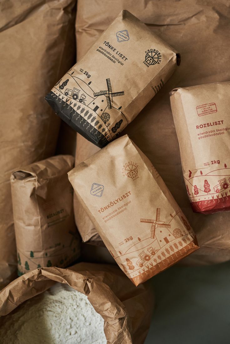 three bags of flour sitting next to each other on top of a bag filled with flour