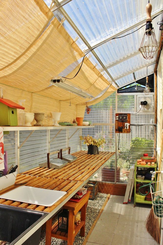 the inside of a greenhouse with lots of plants and vegetables on shelves, hanging from the ceiling