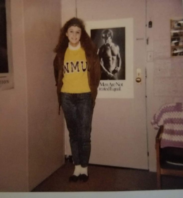 a young woman standing in front of a door