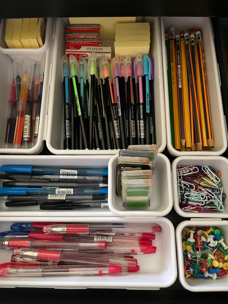 an organized drawer with pens, markers and pencils in it's trays