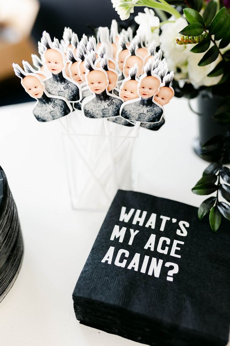 a vase filled with flowers sitting on top of a table next to a black book