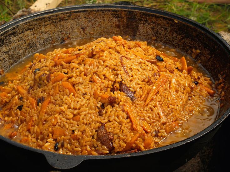 a pot filled with rice and carrots on top of a stove