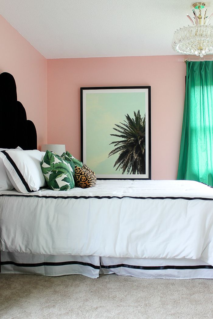 a bedroom with pink walls and green curtains