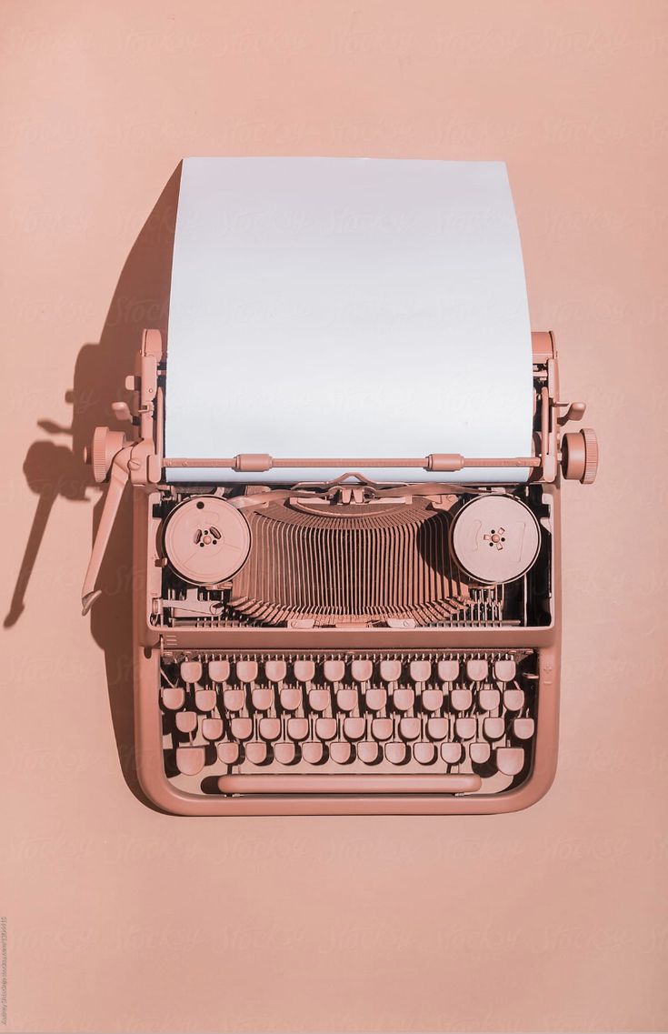 an old fashioned typewriter on a pink background