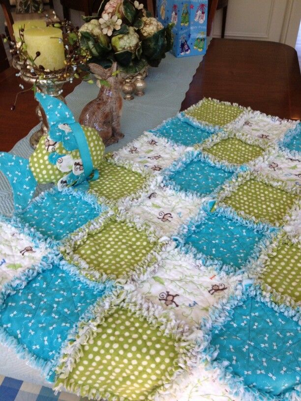 a blue and green quilted table runner on a dining room table next to a vase with flowers