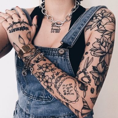 a woman with lots of tattoos on her arm and arms, holding onto some chains