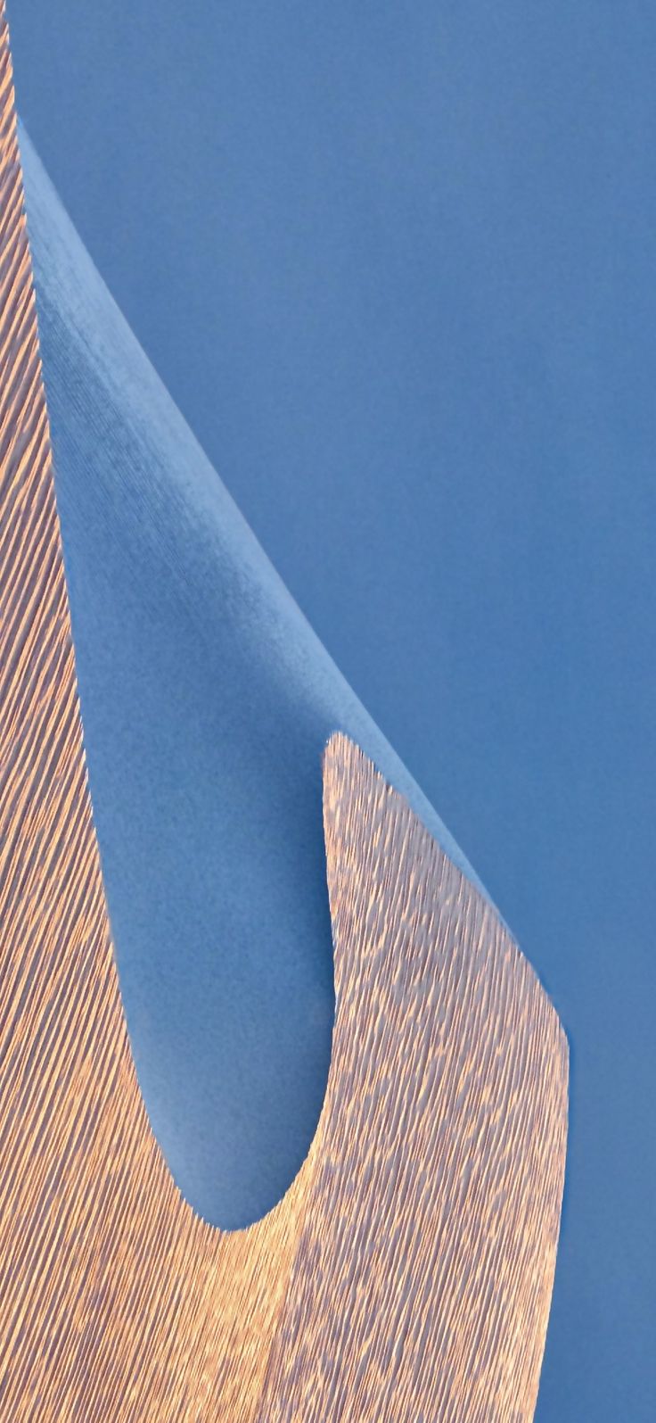 a close up view of a wooden object against a blue background with an interesting design