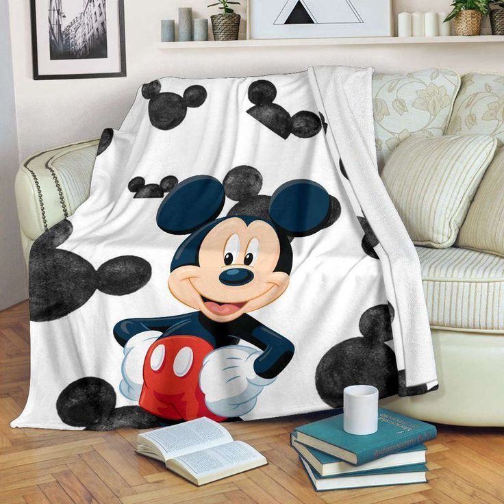 a mickey mouse blanket sitting on top of a couch