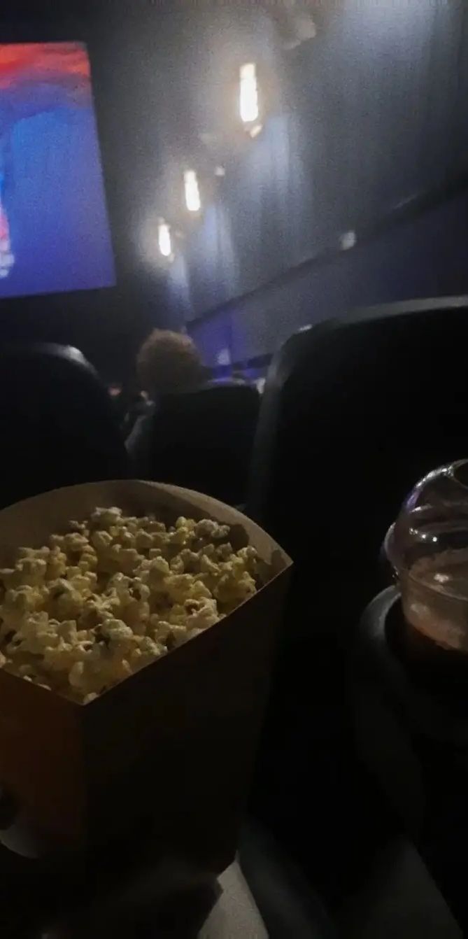 a box filled with popcorn sitting on top of a table in front of a tv