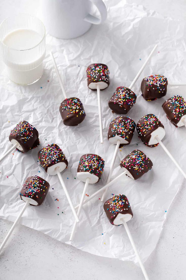 chocolate covered marshmallows and sprinkles on a white tablecloth