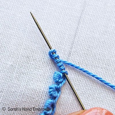 the crochet hook is being used to make an afghan stitch with blue yarn