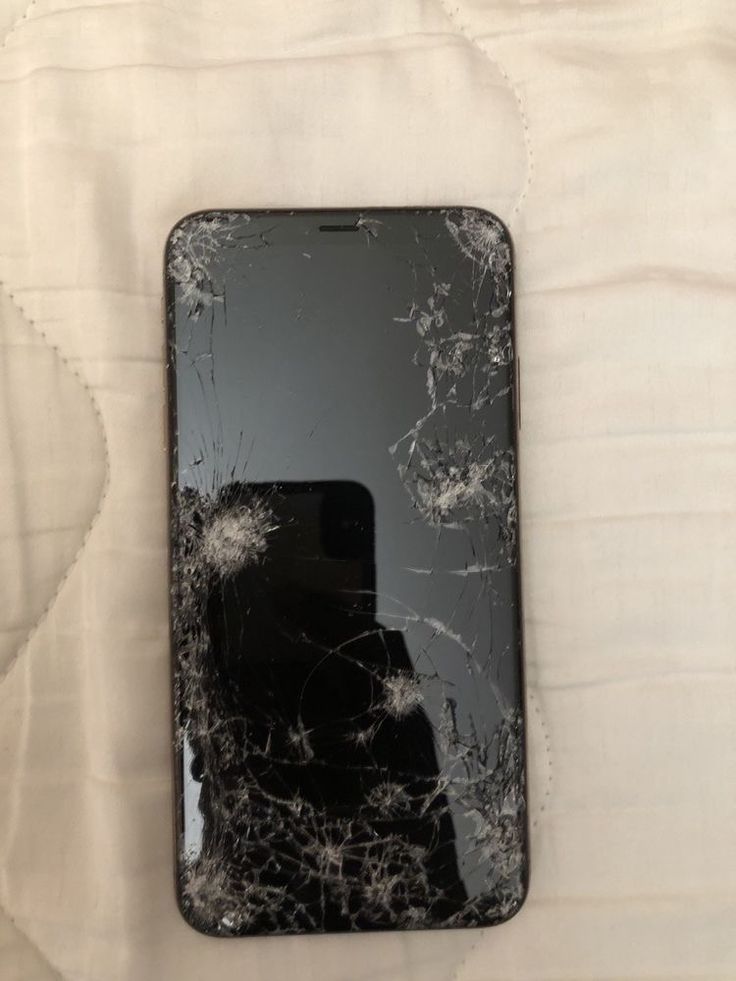 a broken cell phone laying on top of a bed