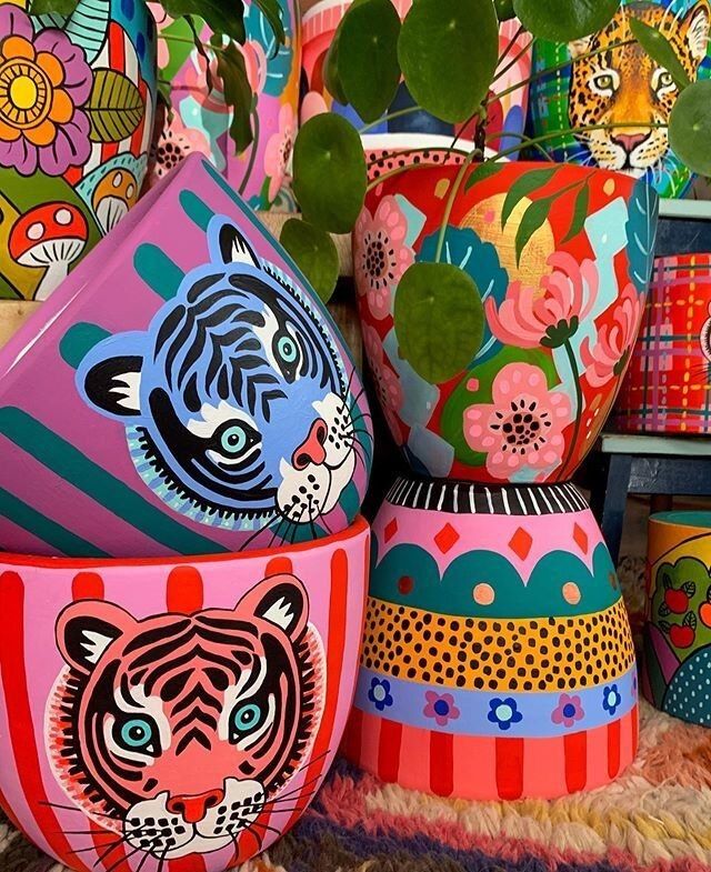 brightly painted vases and plants on display in a store