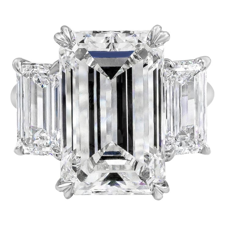 an emerald - cut diamond ring with three baguets on the shoulders and side stones