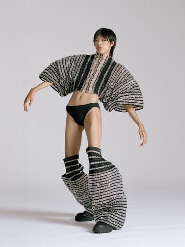 a woman in black and white clothing is posing for a photo with her legs spread out