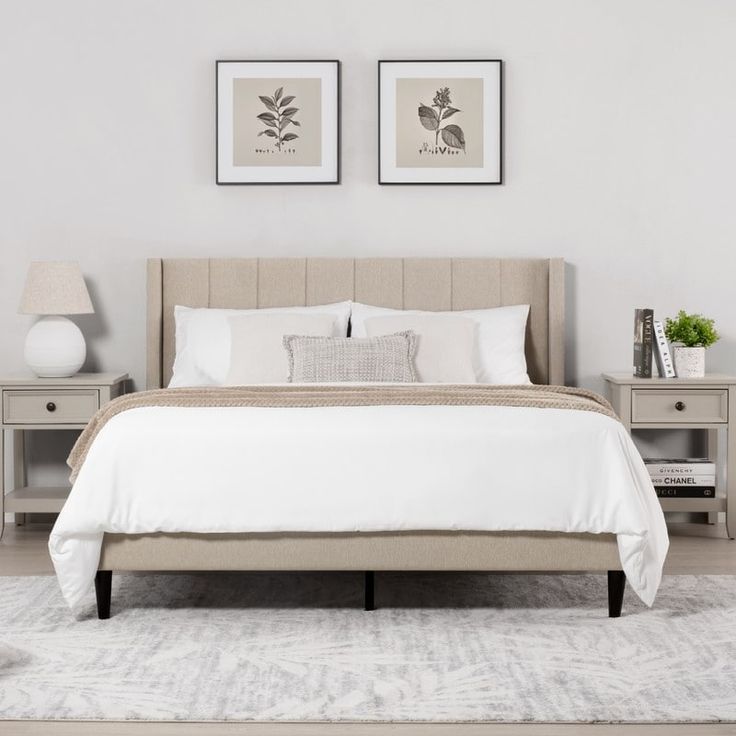 a bedroom with two framed pictures above the bed and an area rug on the floor