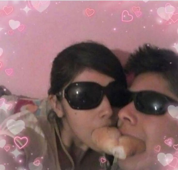 two people wearing sunglasses are kissing each other