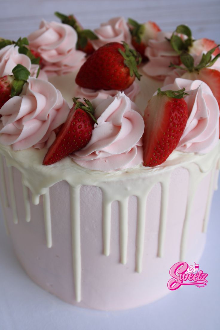 a cake with white frosting and strawberries on top