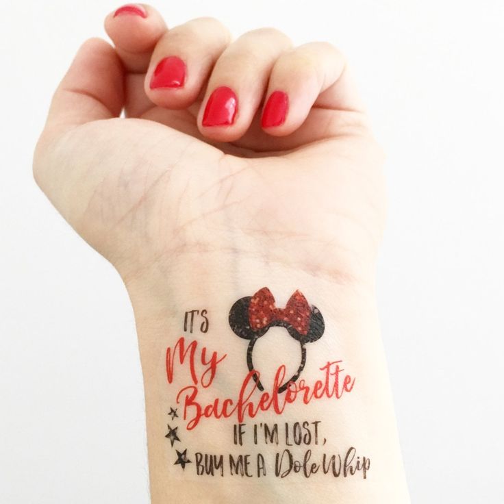 a woman's wrist with a red and black minnie mouse tattoo on her left arm