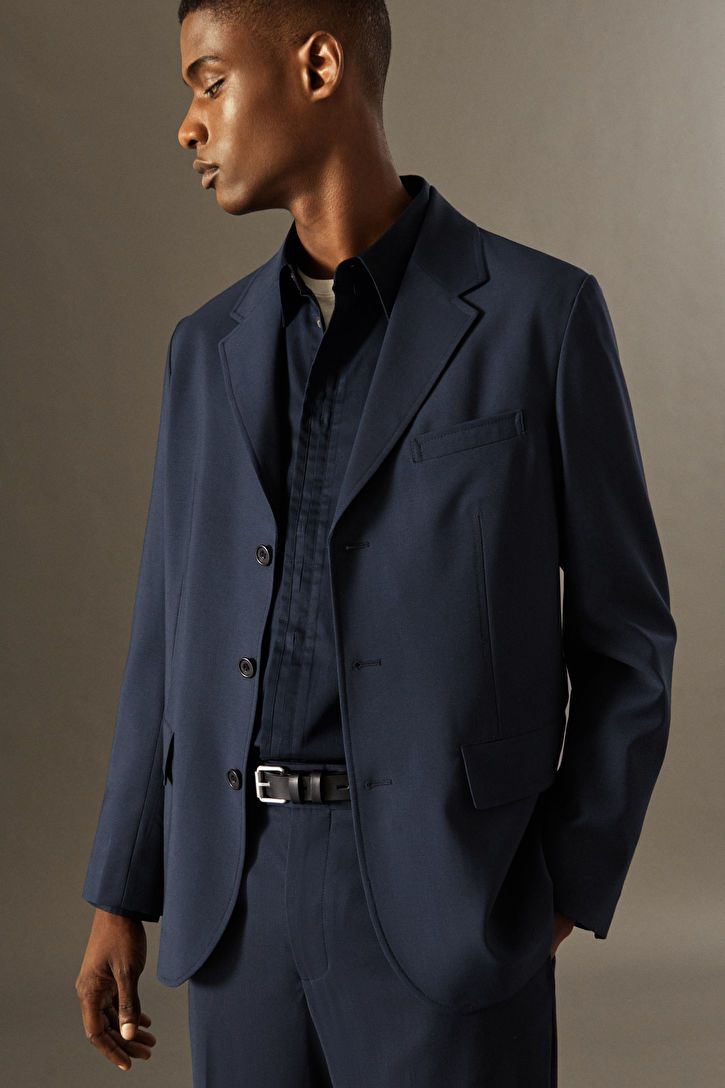 Elegant Unstructured Blazer For Semi-formal Occasions, Elegant Unstructured Semi-formal Blazer, Elegant Semi-formal Unstructured Blazer, Classic Unstructured Blazer For Semi-formal Occasions, Unstructured Classic Blazer For Semi-formal Occasions, Elegant Unstructured Formal Outerwear, Elegant Unstructured Sport Coat With Notch Lapel, Business Outerwear Single Breasted In Suiting Fabric, Unstructured Blazer With Hidden Button For Work