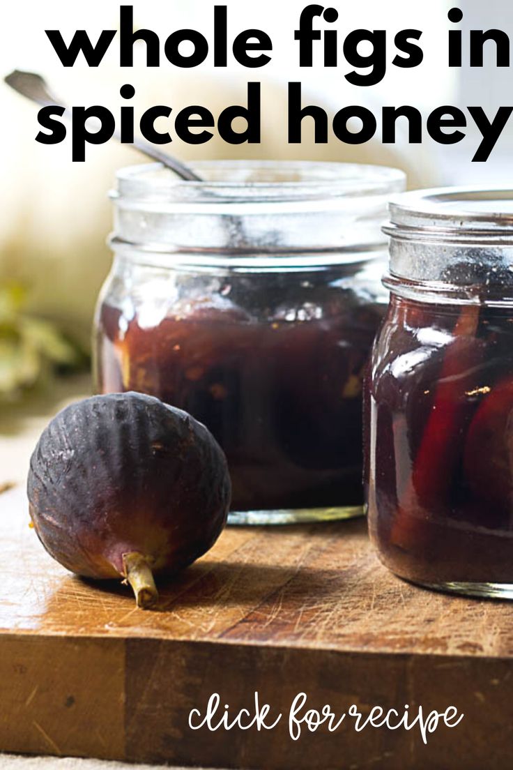 two jars filled with pickled honey sitting on top of a cutting board next to an onion