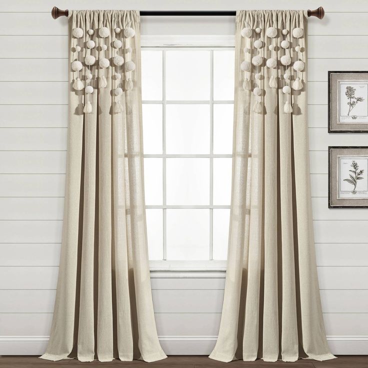 the curtains are hanging in front of a window with white walls and wood flooring