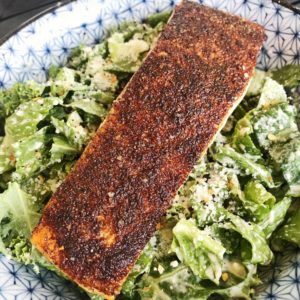 there is a salad with lettuce and fish on the plate in the bowl