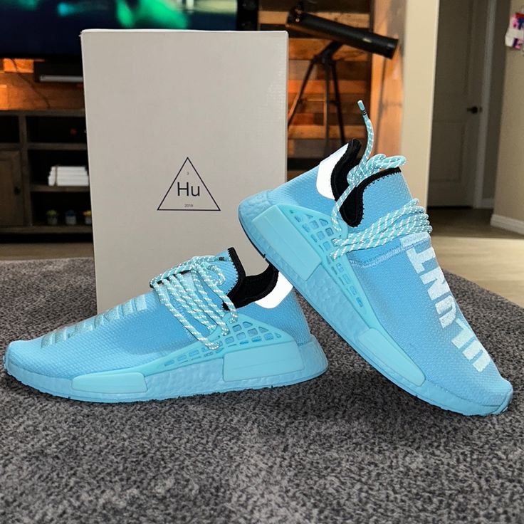 Adidas X Pharrell Nmd Human Race Sneakers The Adidas X Pharrell Williams Nmd Human Race Sneakers Are Undeniably The Perfect Sneakers For The Spring And Summer Season. The Shoe Upper Is Built With Primeknit, Finished In 'Aqua Blue' And Supported By Wraparound Laces Worked Into The Tpu Overlays. Translated To "Human Race" In Xhosa, A Language Spoken In Zimbabwe, The Word 'Uluntu' Is Embroidered Down The Vamp - The Vivid Colour Emboldens His Message - While Black On The Collar Contrasts The Look. C Blue Sneakers For Light Sports With Laces, Blue Sneakers With Laces For Light Sports, Blue Athleisure Sneakers With Laces, Blue Running Shoes With Rubber Waffle Outsoles For Streetwear, Blue High-top Lace-up Sneakers With Rubber Waffle Outsoles, Blue Lace-up High-top Sneakers With Rubber Waffle Outsoles, Light Blue Lace-up Running Shoes For Streetwear, Blue Running Shoes With Laces For Light Sports, Blue Breathable High-top Sneakers For Running