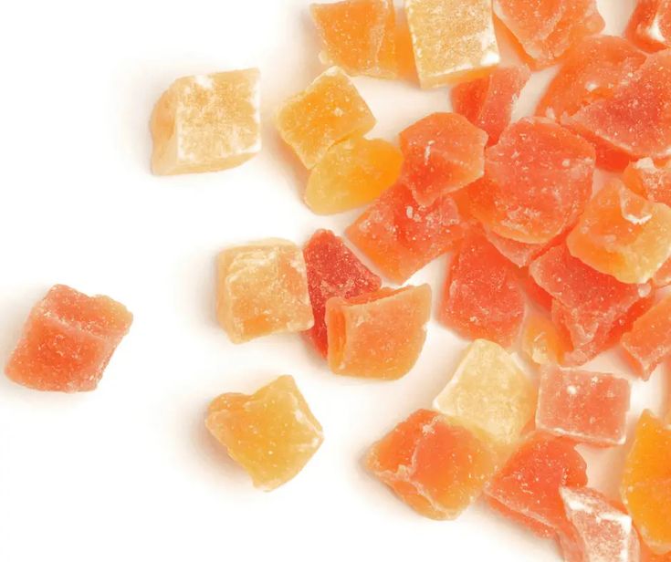 pieces of gummy bears sitting next to each other on a white surface with one cut in half