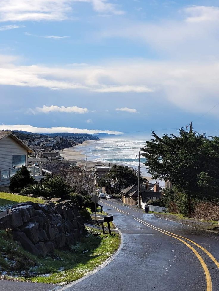 an empty street next to the ocean and houses