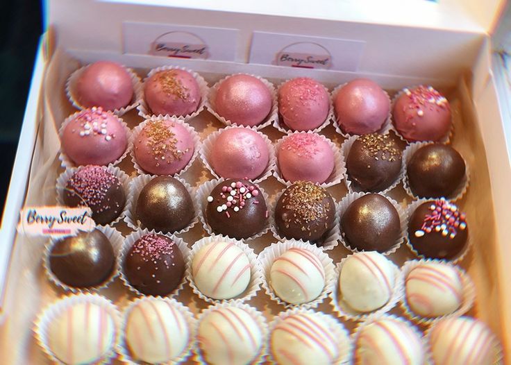 a box filled with lots of different types of cake truffles on top of each other