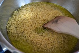 rice is being cooked in a pot with a wooden spoon on the side and green liquid coming out of it