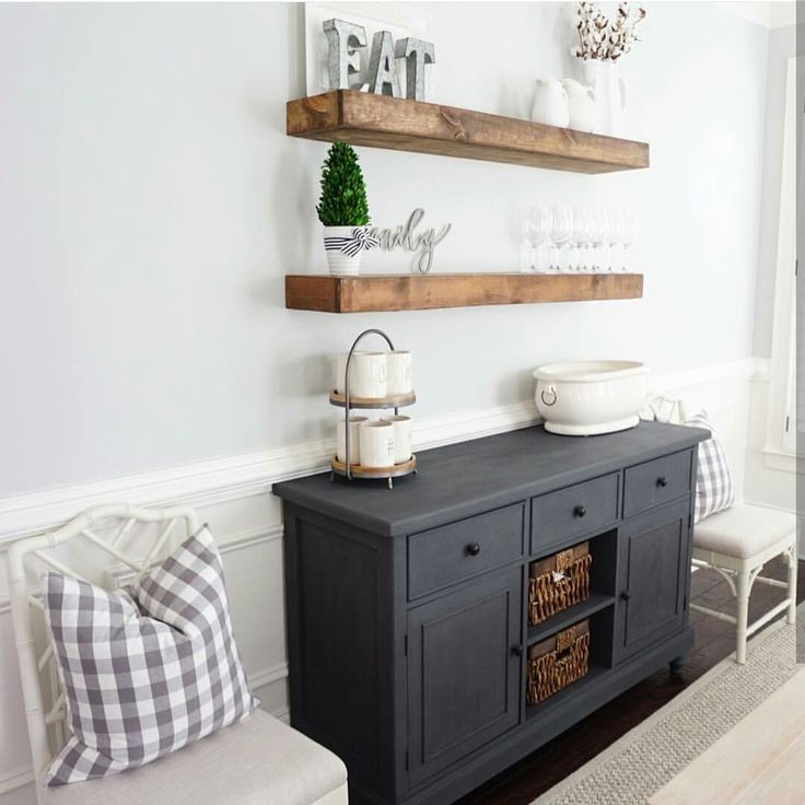 a living room filled with furniture and two shelves on the wall next to a window