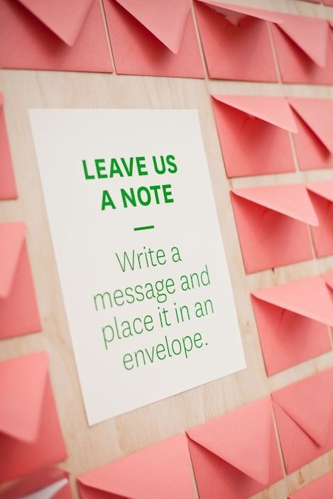 a sign on a wall that says leave us a note write a message and place it in an envelope