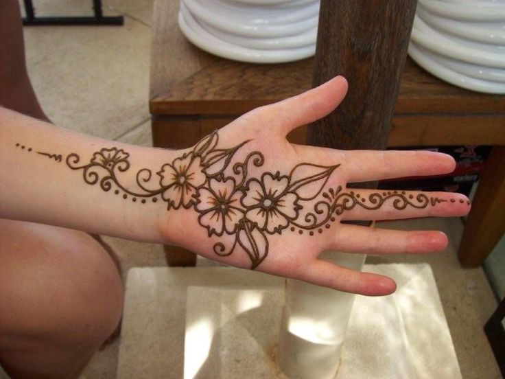 a woman's hand with henna tattoos on it