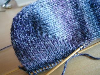 a blue and white knitted hat sitting on top of a table