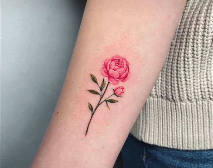 a pink rose tattoo on the left arm