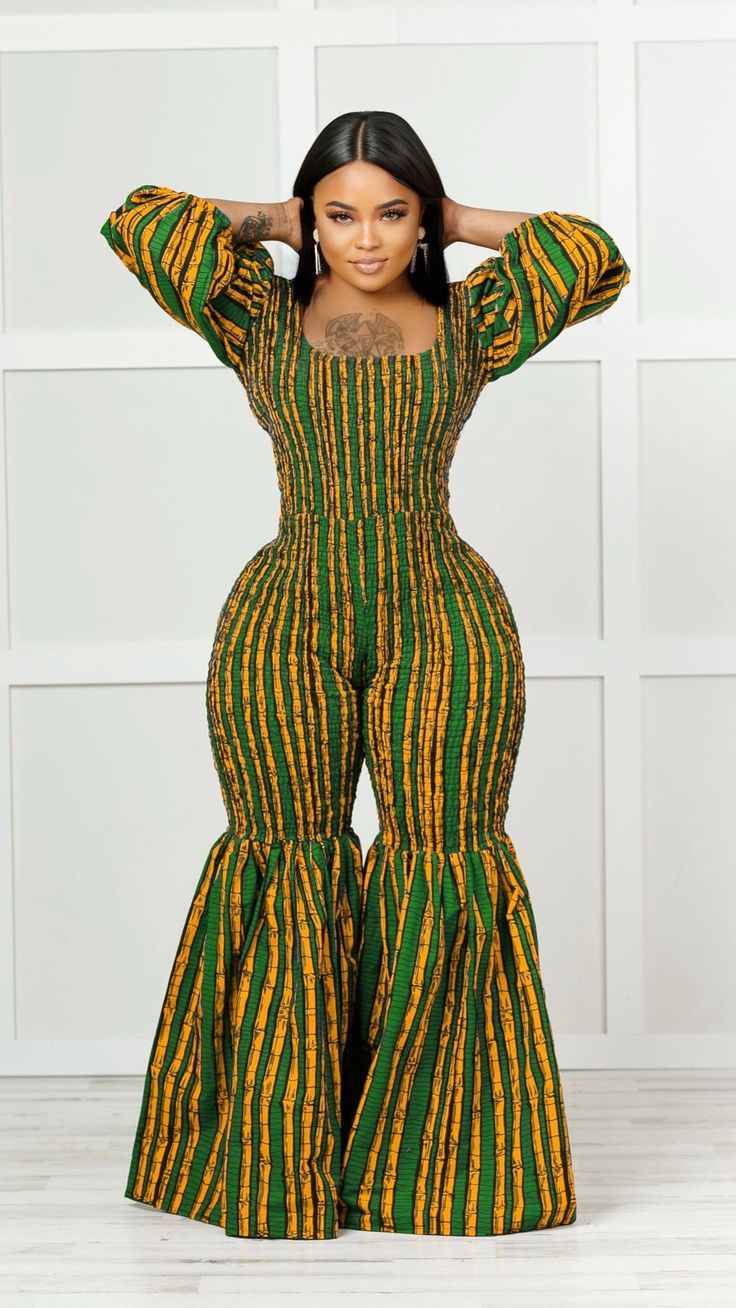 Make a bold fashion statement in this African print jumpsuit. The bell-bottom silhouette is a stylish way to show off your curves and add a touch of flair to any look. Crafted from a soft and stretchy material, this jumpsuit is perfect for any occasion. The vivid pattern features tribal style designs that add a unique and stylish touch to the look. Wear this vibrant piece with a pair of heels, and have an outfit that looks great all day long. This jumpsuit is made of 100% African cotton and is e Spring Flare Fitted Jumpsuits And Rompers, Chic Fitted Multicolor Jumpsuits And Rompers, Fitted Printed Jumpsuits And Rompers, Chic Fitted Flare Jumpsuits And Rompers, Jumpsuit Outfit African Print, African Print Overalls, African Print Jumpsuit Rompers, Green Fitted Wide-leg Jumpsuits And Rompers, African Jumpsuit