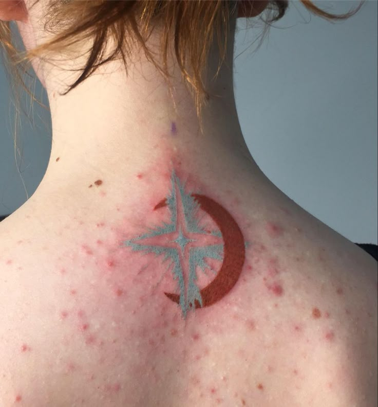 the back of a woman's neck with red and blue spots on her skin