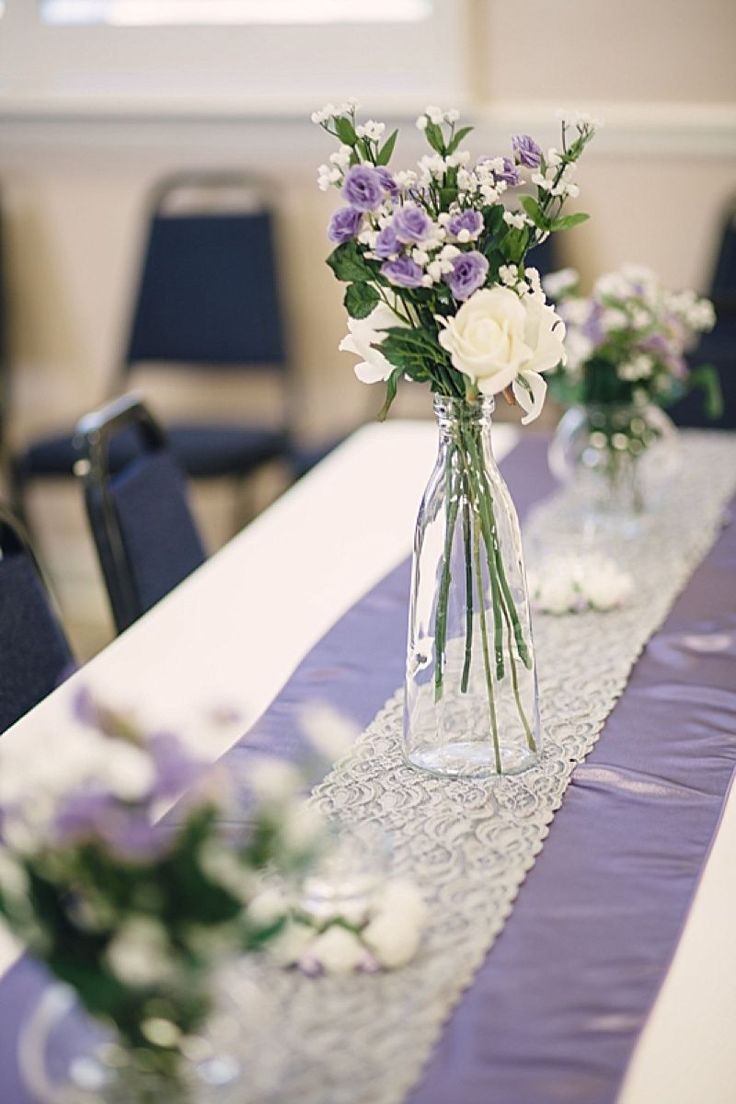 two vases filled with flowers sitting on top of a table