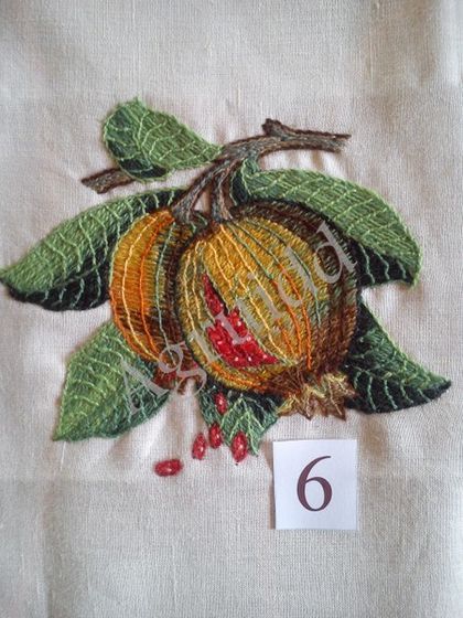 an embroidered piece of cloth with leaves and berries on it, next to the number six