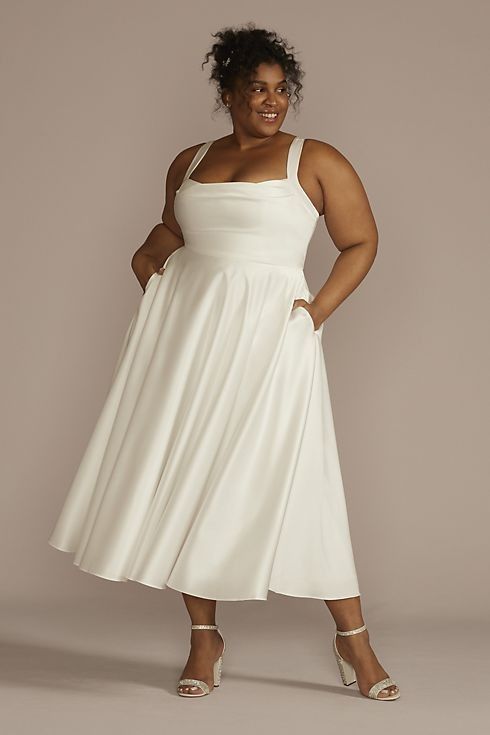 a woman in a white dress posing for the camera with her hands on her hips