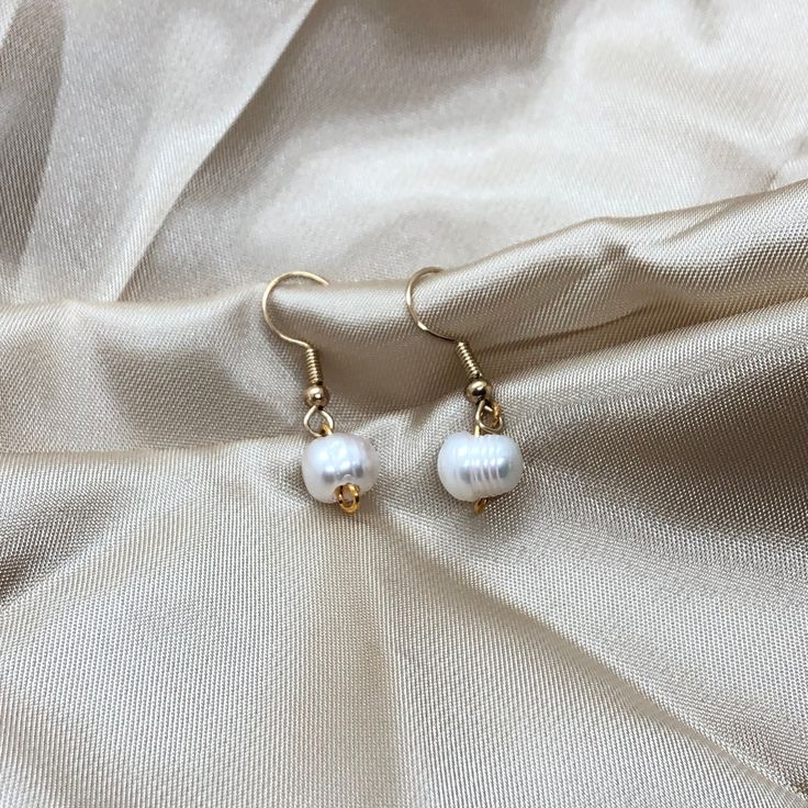 This is an elegant, minimalist , Pearl earring. These earrings are a great gift for anyone or a piece to level up your collection! -DETAILS- - Ivory Freshwater Pearl  - Gold colour hardware - Water resistant  -CARE-  - To avoid extreme tarnishing reduce contact with lotions, oils, and fragrances  - No abrasive materials should come in contact with the piece  - To clean simply fill a bowl with some soapy water do a cloth into the water and wipe  - If you need any repairs feel free to message us -SHIPPING- - We ship all of our orders with regular letter mail  - All of our orders are packaged with love and care -QUESTIONS- - If you have any questions or concerns feel free to message us  - If you want an order specially packaged you can message with requirements  - You can always personalize y Elegant White Everyday Earrings, Pearl White Round Earrings For Everyday, Adjustable Minimalist Pearl Earrings For Pierced Ears, Minimalist Adjustable Pearl Earrings, Adjustable Minimalist Pearl Earrings, Everyday Pearl White Drop Earrings, Pearl White Drop Earrings For Everyday Wear, Delicate White Pearl Earrings For Everyday, Handmade Minimalist Pearl Drop Earrings