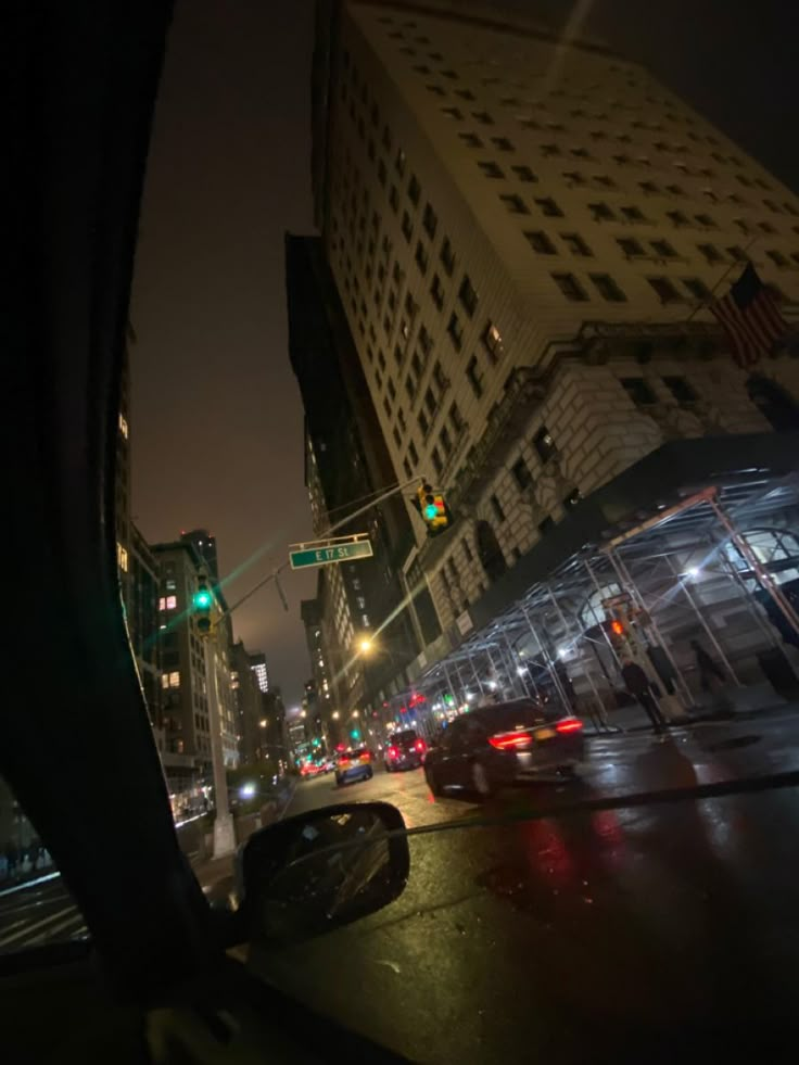 a city street at night with traffic lights and tall buildings