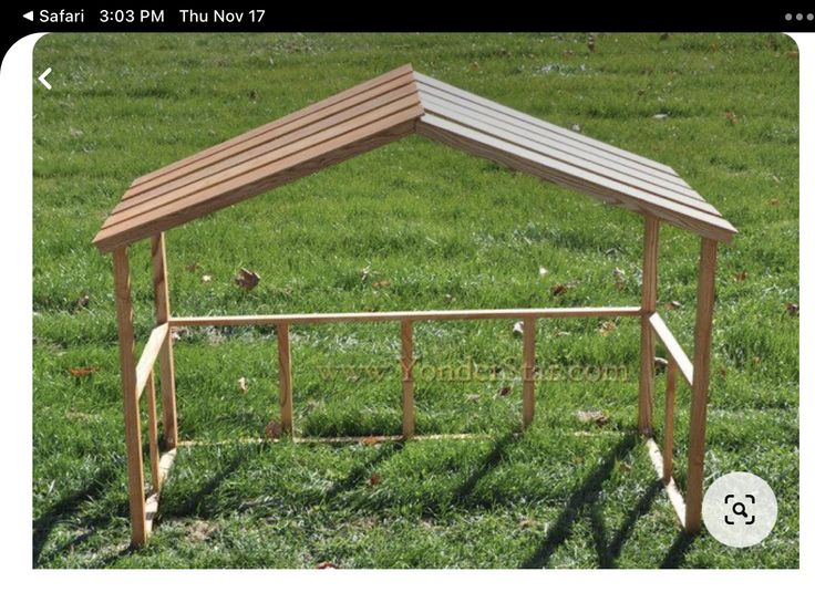 a small wooden structure sitting on top of a lush green field