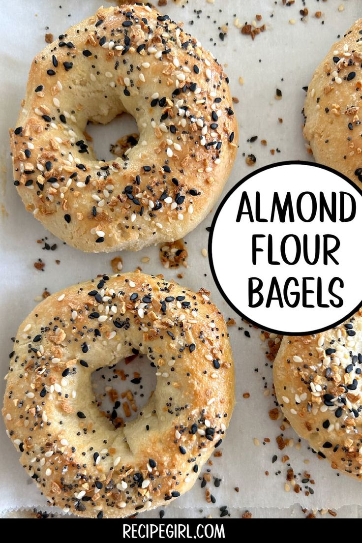 four bagels with black sesame seeds on top and the words almond flour bags above them